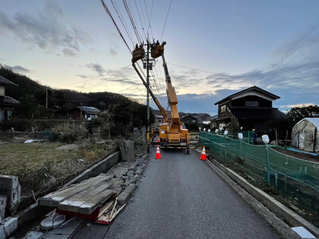 住宅街で配電線の修理。手前には倒壊したブロック塀がある。