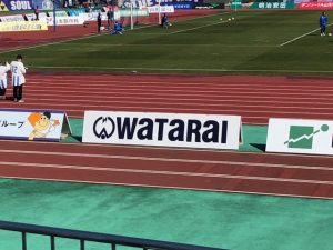 渡会電気土木のアドボードを拡大した写真。会社のマークと「WATARAI」の文字が書かれている。