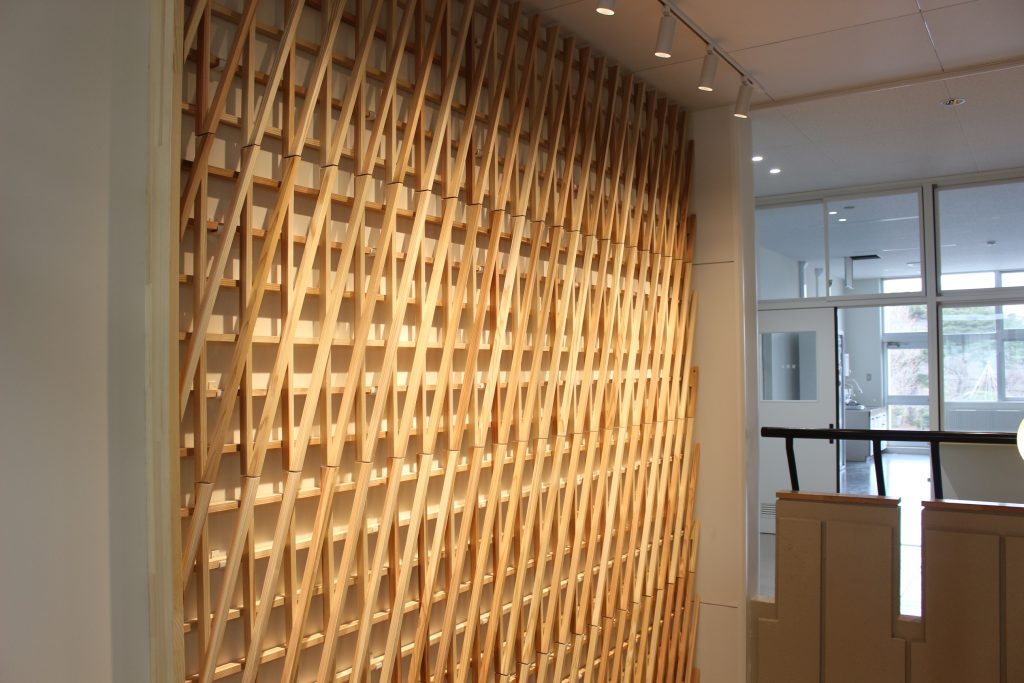 メディアホール壁の装飾。木材が組み合わさって模様を作っている。2F吹き抜けから撮影。