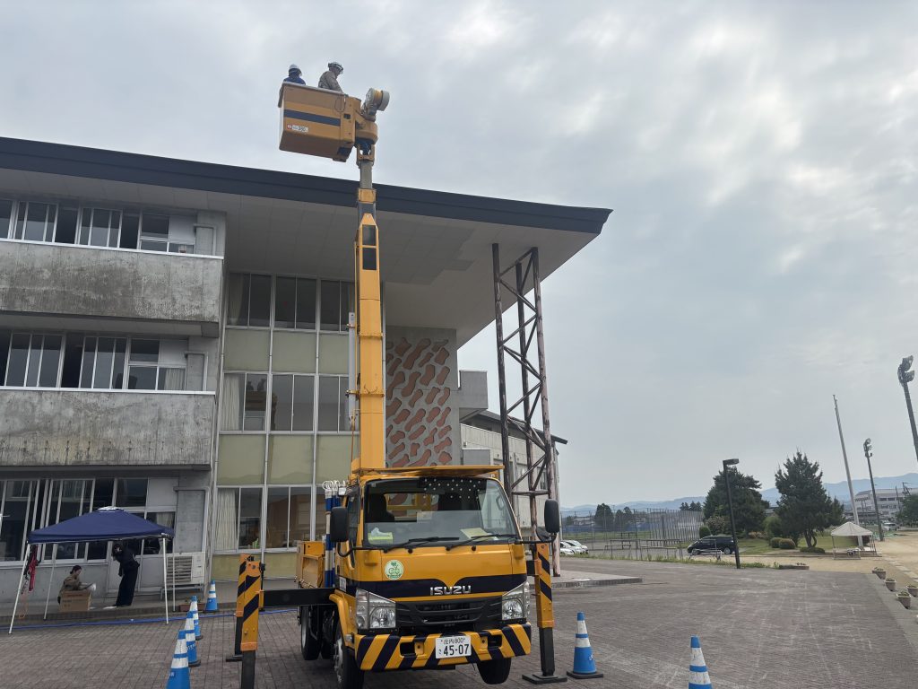 高所作業車に社員と生徒が乗っている