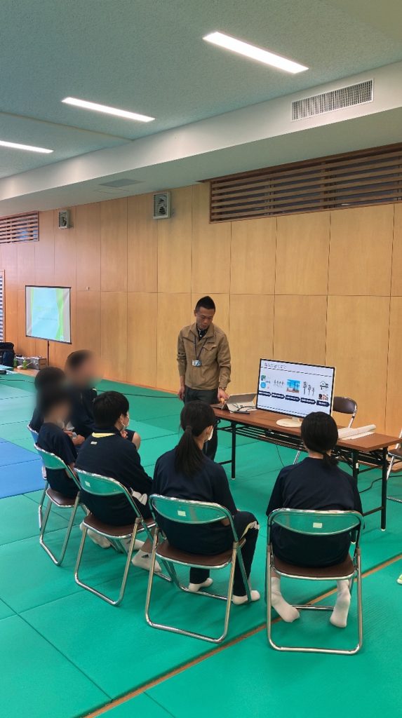 社員が生徒6名に企業説明をしている