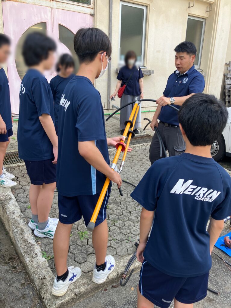 配電線を工具で持ってみる体験中の様子