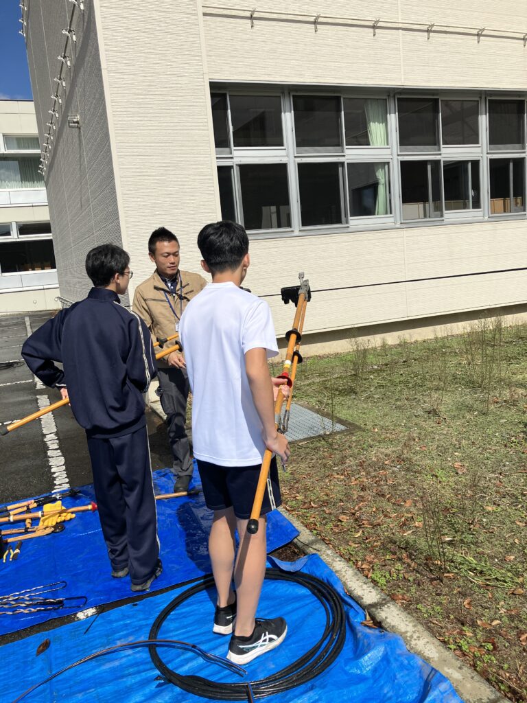 配電線のクリップをつける体験中の様子