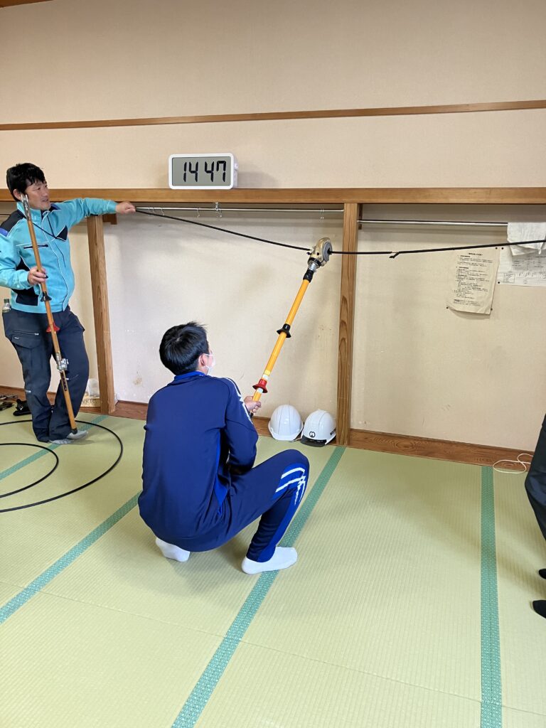 室内で配電線の皮むき体験中の様子