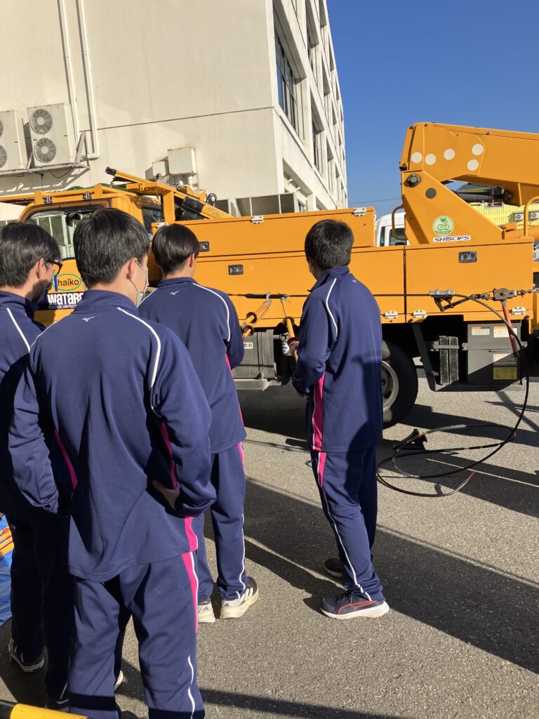 配電線にカバーをつける体験中の様子