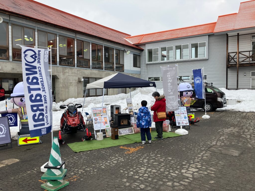 当社ブースにてペレットストーブとスノーモービルを展示している様子